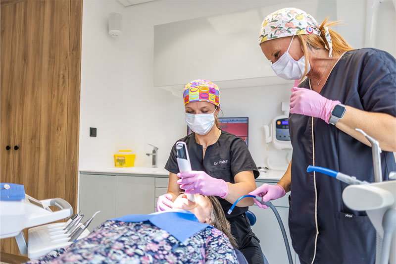 Dentiste et assistante dentaire réalisant un soin au Cabinet dentaire de l'Ermitage